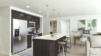 a kitchen with a center island and a stainless steel refrigerator